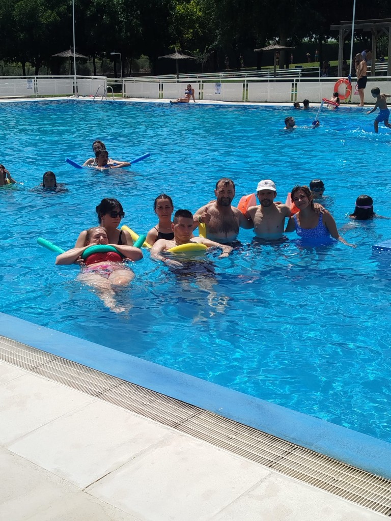 Personas usuarias del centro disfrutando del baño adaptado en las instalaciones de la piscina municipal.